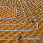 Orange posed Underfloor heating tube in a construction site